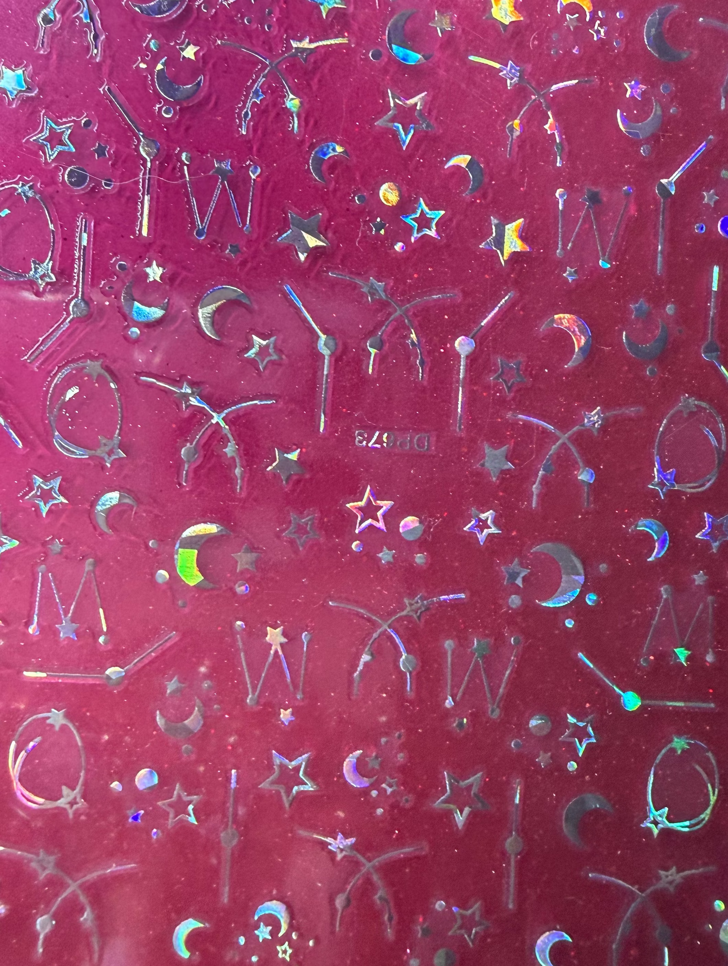 Transparent sheet with metallic letter and symbol stickers on a red background